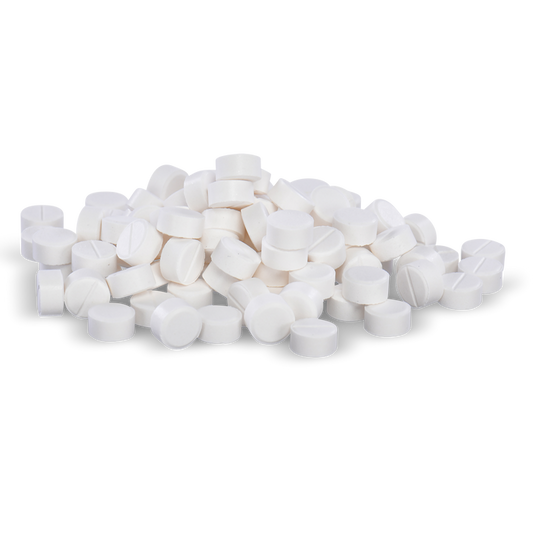 White pills are piled on a black background.