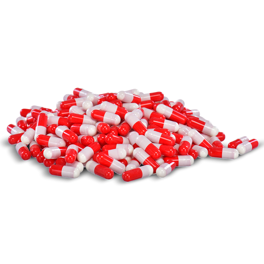 Red and white capsules are piled in a heap against a black background.