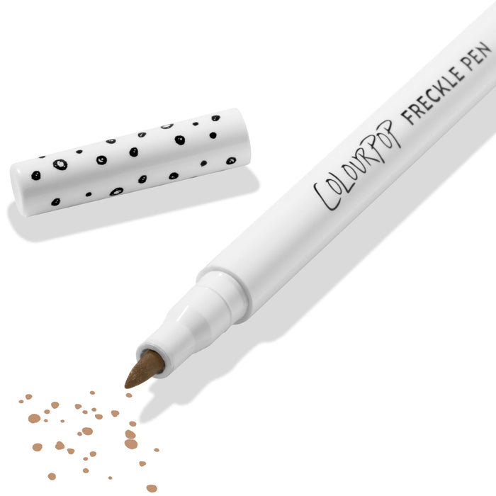ColourPop Freckle Pen in Soft Brown uncapped, felt-tip applying scattered soft brown freckle dots, with polka-dot white cap beside it on a clean white background; long-wearing, buildable faux freckles makeup.
