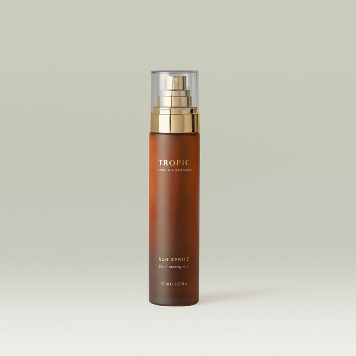 Sun Spritz Facial Tanning Mist by Tropic in an amber glass bottle with a fine mist spray, designed to deliver a natural-looking facial glow with a lightweight, buildable finish.