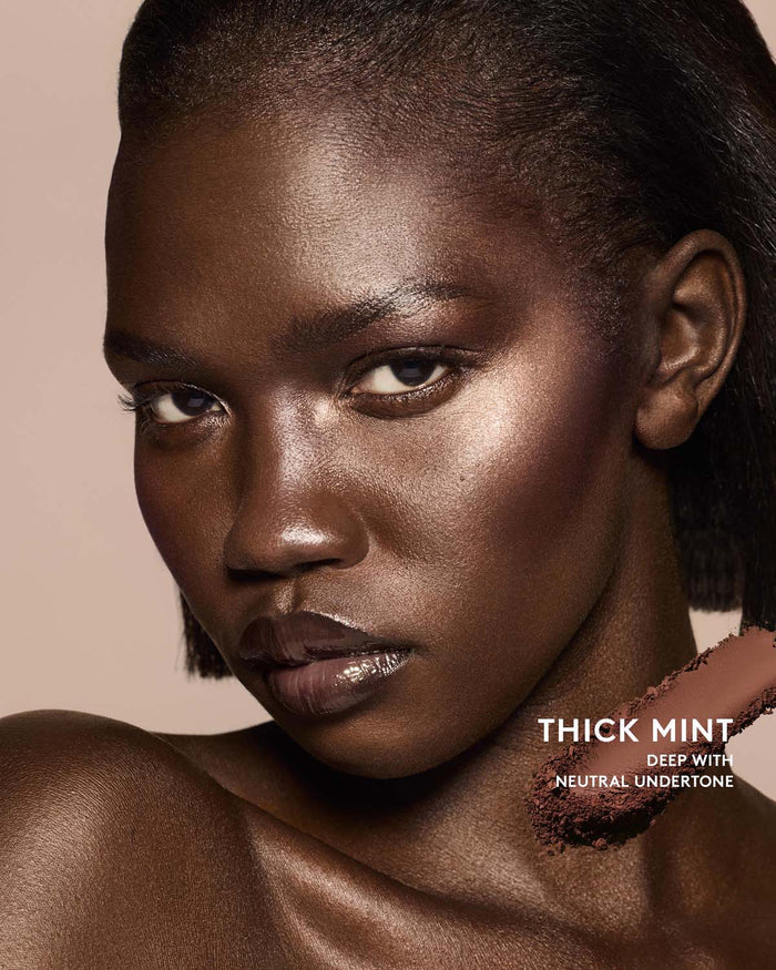 Deep skin tone model wearing sun stalk'r bronzer in shade Thick Mint.