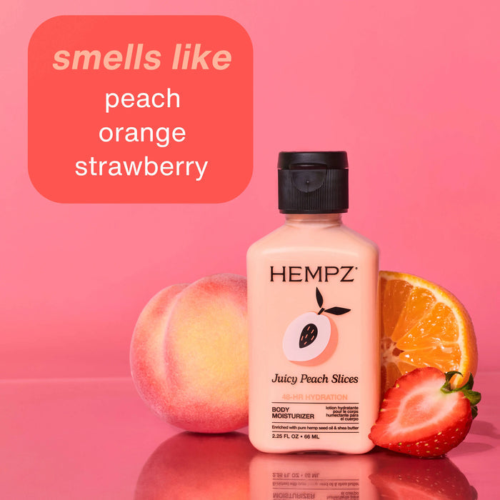 Hempz Juicy Peach Slices Travel-Size body moisturizer bottle with peach, orange, and strawberry on a pink background