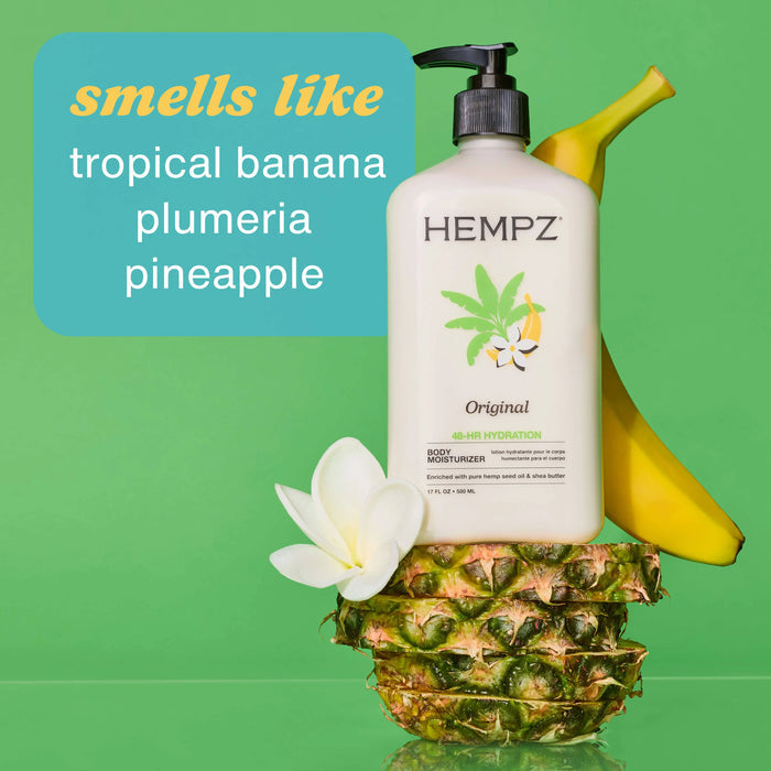 Hempz body moisturizer on a pineapple with a banana and flower, against a green background.