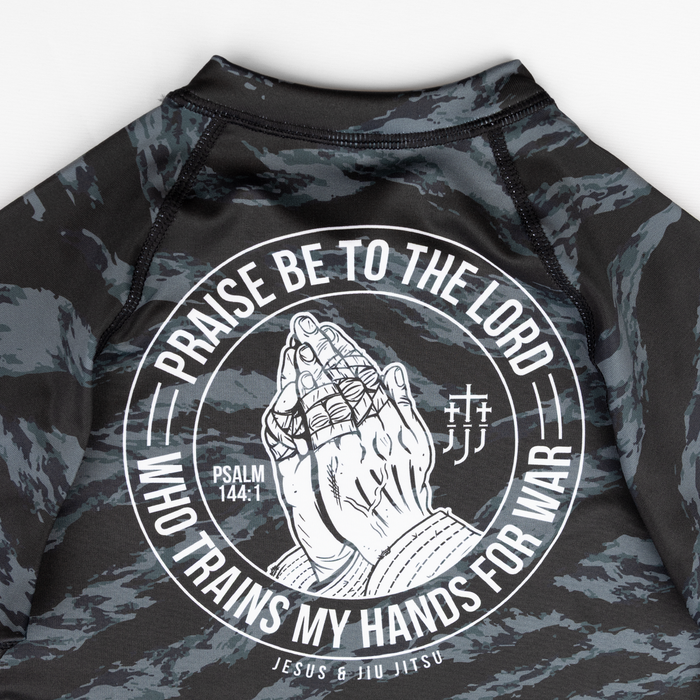 Closeup of praying hands graphic on back of ladies camo rashguard