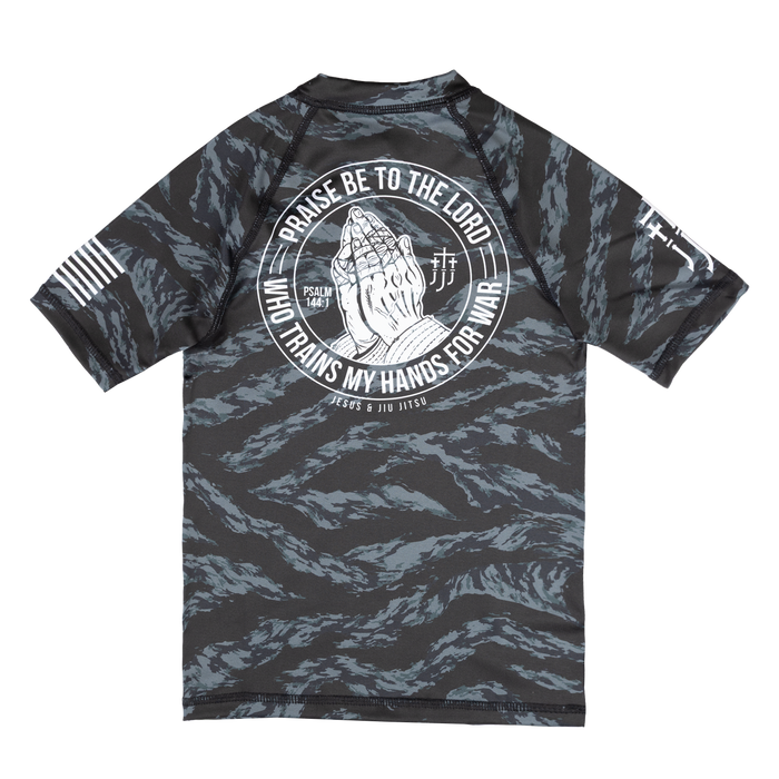 Youth Rashguard with a graphic design on the back featuring praying hands and text, on a white background.