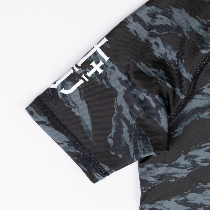 JJJ logo on sleeve of youth camo rashguard